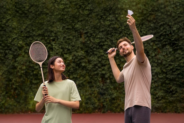 Foto gratuita gente de tiro medio jugando al bádminton.