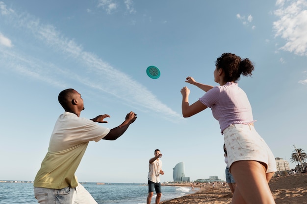 Gente de tiro medio jugando en la playa