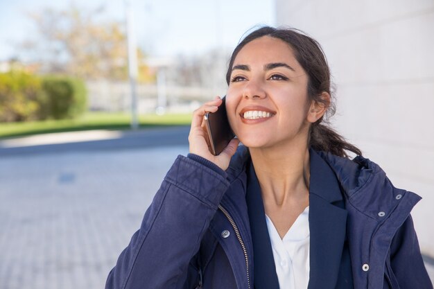 Gerente alegre feliz que tiene conversación agradable del teléfono