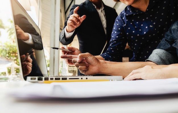 Gerente asiático de la mujer de negocios que analiza datum en cartas y que mecanografía en la computadora, haciendo notas en documentos en la mesa en la oficina, color de la vendimia, foco selectivo. Concepto de negocio.