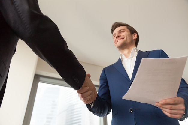 Gerente de compañía sonriente que da la bienvenida al cliente en oficina