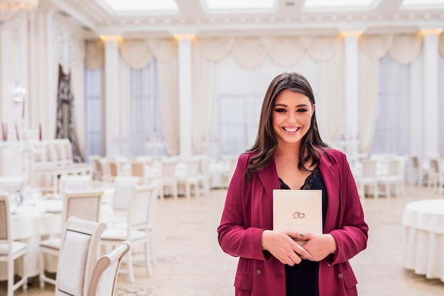 Foto gratuita gerente de eventos feliz en el salón de banquetes