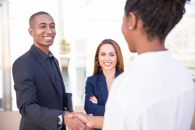 Gerente hombre afroamericano feliz estrechar la mano de la pareja