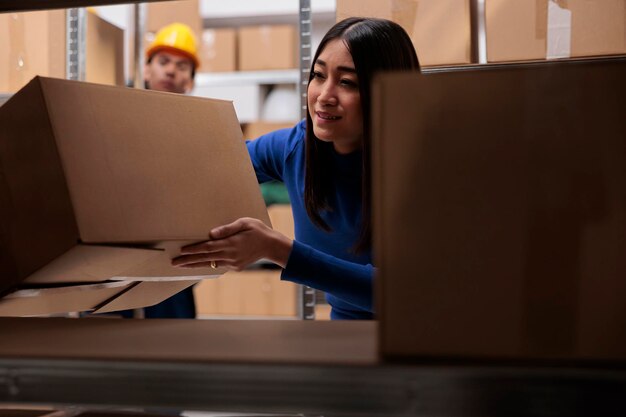 Gerente de logística haciendo control de calidad de paquetes de mercancías mientras busca cajas de cartón en el estante. Empleado del almacén minorista de comercio electrónico que tiene un paquete para empacar el pedido del cliente para su envío