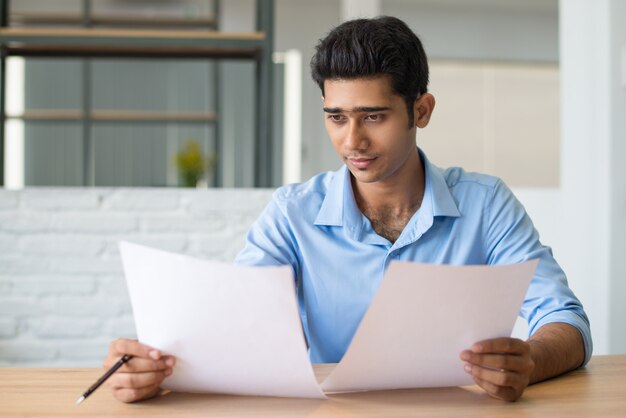 Gerente masculino concentrado mirando atentamente el documento