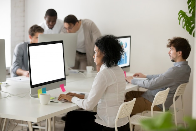 Gerente de una mujer afroamericana centrada en el trabajo con computadoras en una oficina multiétnica