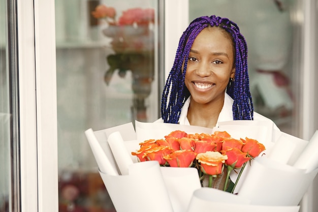 Gerente de mujer de pie en el lugar de trabajo. señora con planta en manos. floreria mujer feliz en centro floral concepto de floristería.