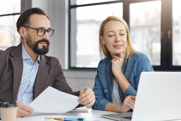 Gerente mujer rubia feliz tiene conversación con colega masculino