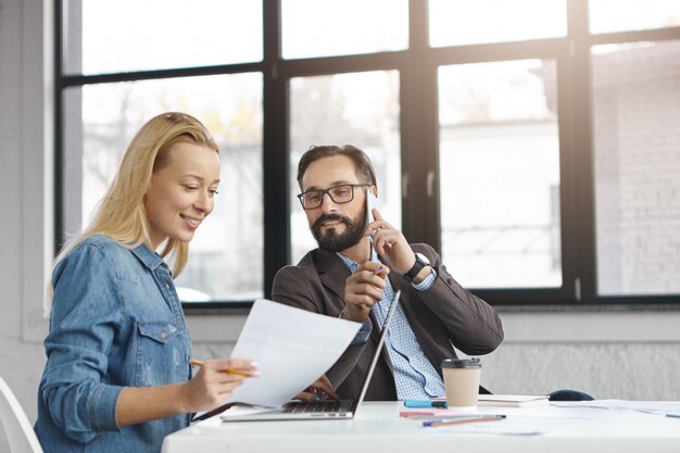 Gerente mujer rubia feliz tiene conversación con colega masculino