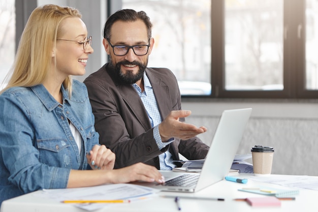 Gerente mujer rubia feliz tiene conversación con colega masculino