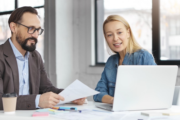 Gerente mujer rubia feliz tiene conversación con colega masculino