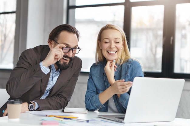 Gerente mujer rubia feliz tiene conversación con colega masculino