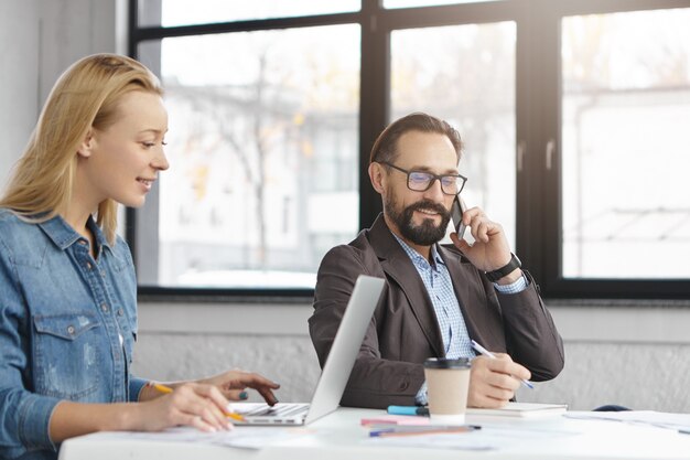 Gerente mujer rubia feliz tiene conversación con colega masculino