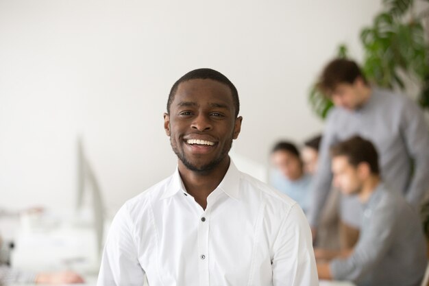 Gerente profesional afroamericano feliz sonriendo mirando a cámara, retrato en la cabeza