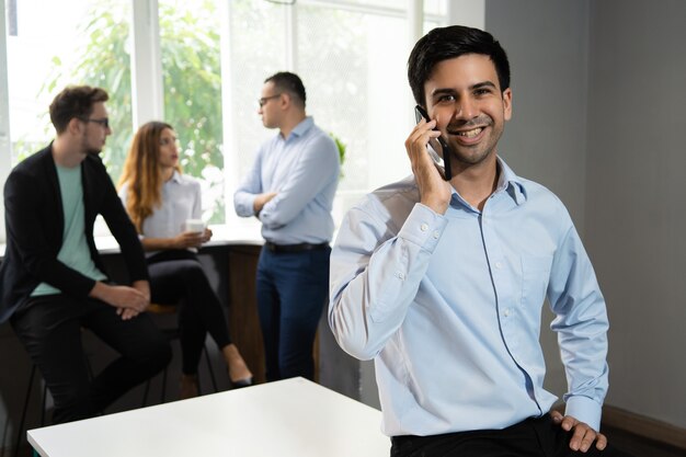 Gerente sonriente hablando por teléfono móvil