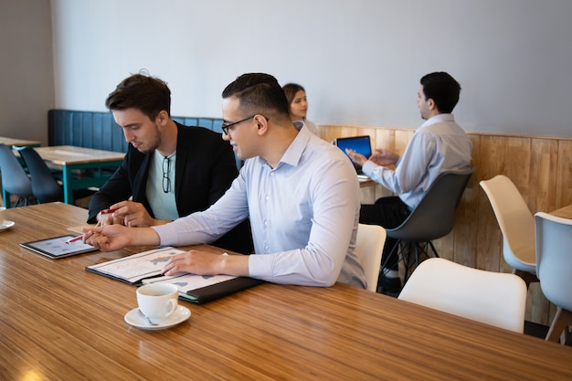 Foto gratuita gerentes discutiendo el informe de ventas durante la pausa del café