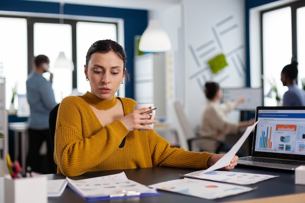 Gestión de la lectura de la empresa financiera analizando estadísticas en el lugar de trabajo. Emprendedor ejecutivo, líder gerente sentado trabajando en proyectos con diversos colegas.