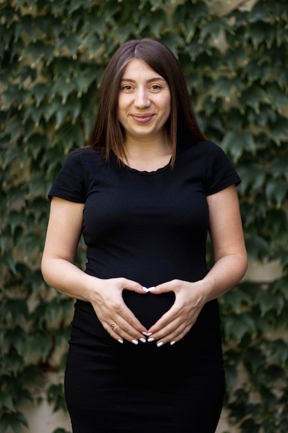 Foto gratuita gesto de mano en forma de corazón de mujer embarazada