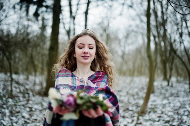 Ggirl sosteniendo corona en las manos en el bosque nevado en día de invierno