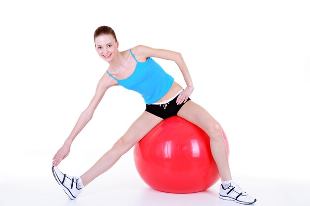 Gimnasia con fitball de la hermosa joven - aislada