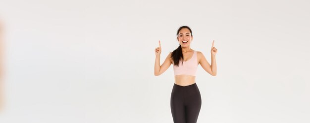 Gimnasio deportivo y concepto de cuerpo saludable de longitud completa de atleta femenina alegre sonriente asiática fitness girl