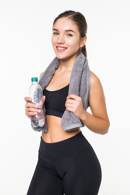 Gimnasio deportivo mujer muscular agua potable, aislado contra la pared blanca