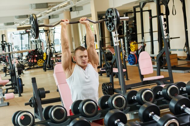 Gimnasio. Hombre guapo durante el entrenamiento