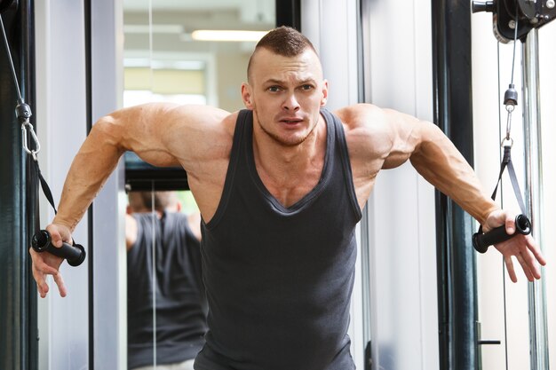 Gimnasio. Hombre guapo durante el entrenamiento