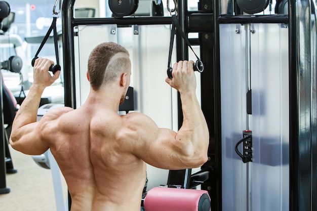 Gimnasio. Hombre guapo durante el entrenamiento