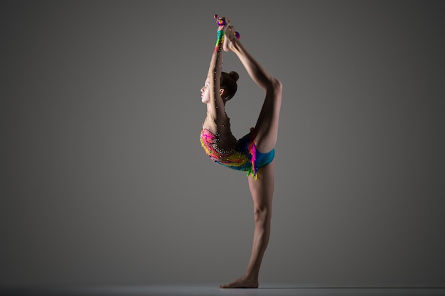 Foto gratuita gimnasta chica haciendo backbend de pie con maza