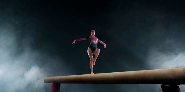 Gimnasta femenina haciendo un truco complicado en la barra de equilibrio de gimnasia en un campo profesional