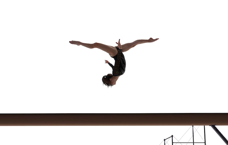 Foto gratuito gimnasta femenina haciendo un truco complicado