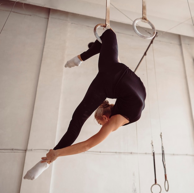 Gimnasta rubia haciendo un ejercicio complicado