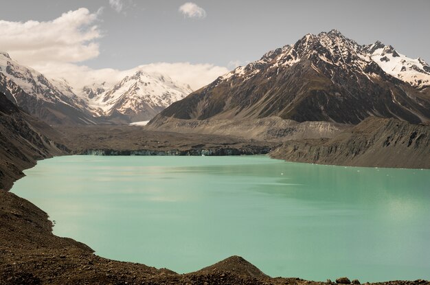 Glaciar Hooker rodeado de rocas cubiertas de nieve en Nueva Zelanda