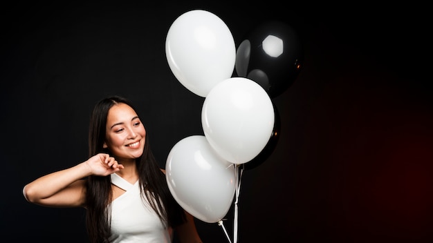 Glamorosa mujer posando con globos en fiesta