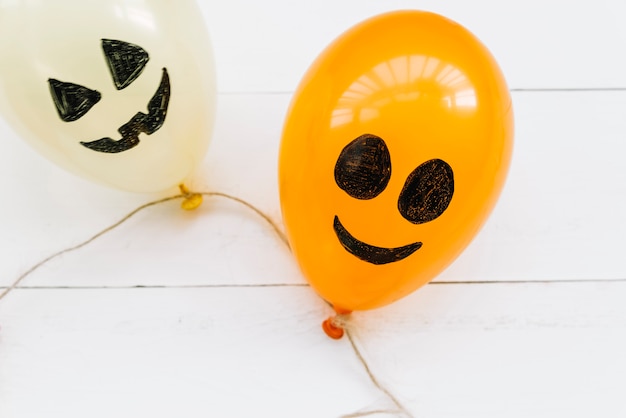 Globos aerostáticos blancos y anaranjados con caras pintadas espeluznantes