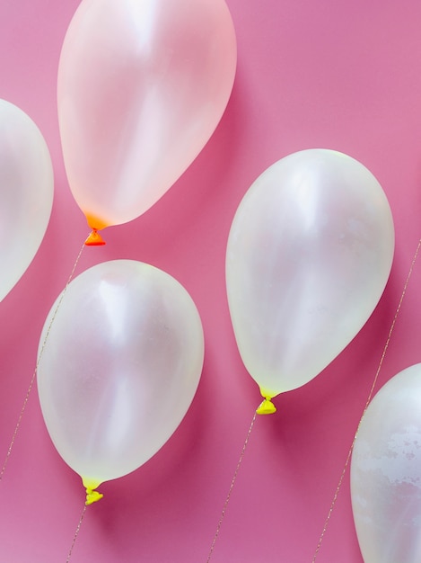 Globos blancos sobre fondo rosa