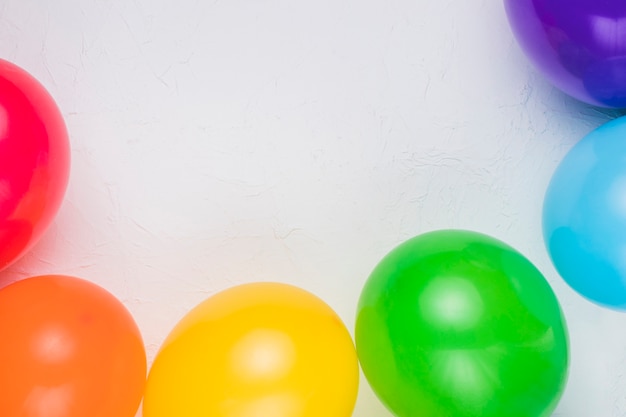 Foto gratuita globos de colores dispuestos en superficie blanca