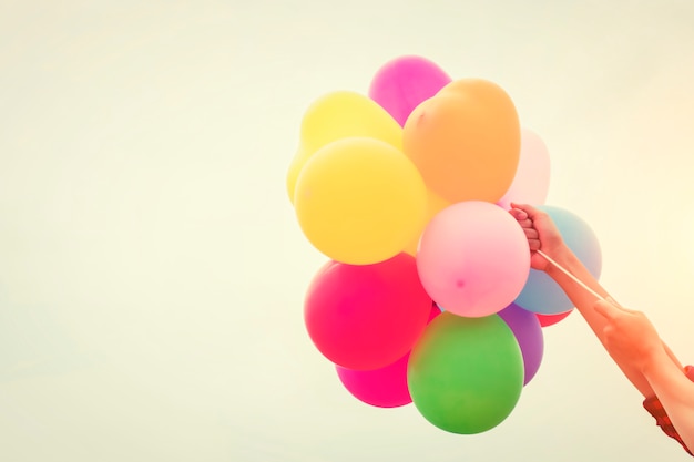 Globos de colores sujetados por brazos