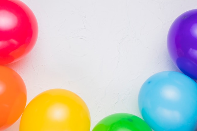 Foto gratuita globos de colores en superficie blanca