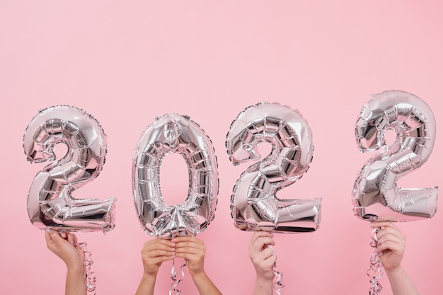 Globos festivos desde los números sobre un fondo rosa