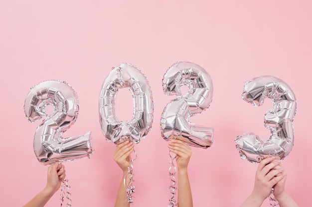 Globos festivos desde los números sobre un fondo rosa