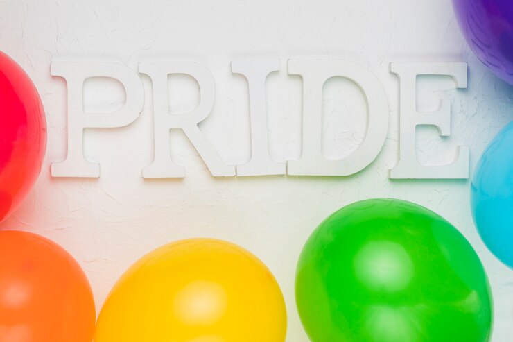 Foto gratuito globos multicolores y palabra orgullo.