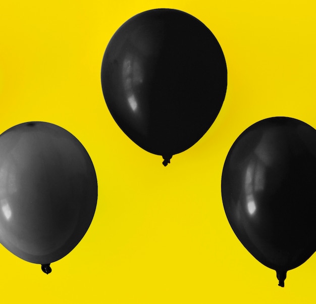 Globos negros sobre fondo amarillo