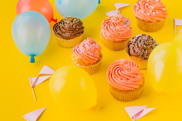 Foto gratuita globos y pastelitos con aspersión