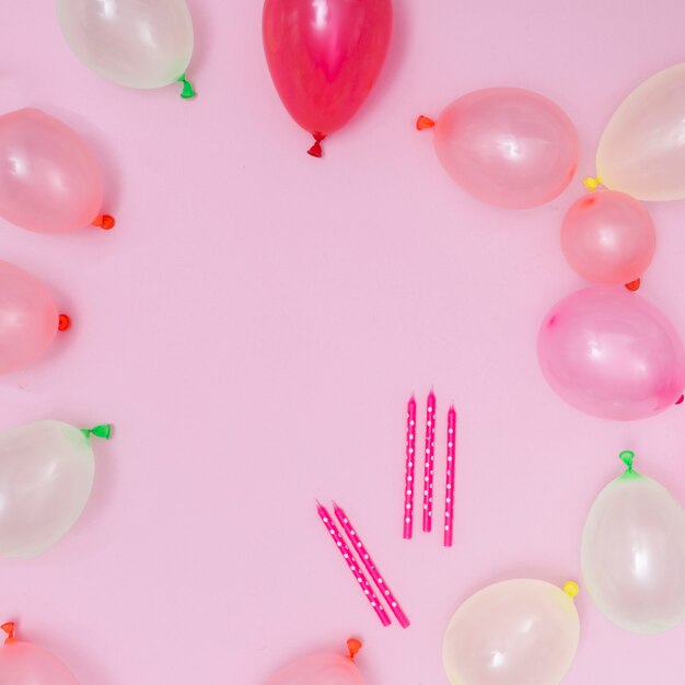 Globos rosados y blancos sobre fondo rosa