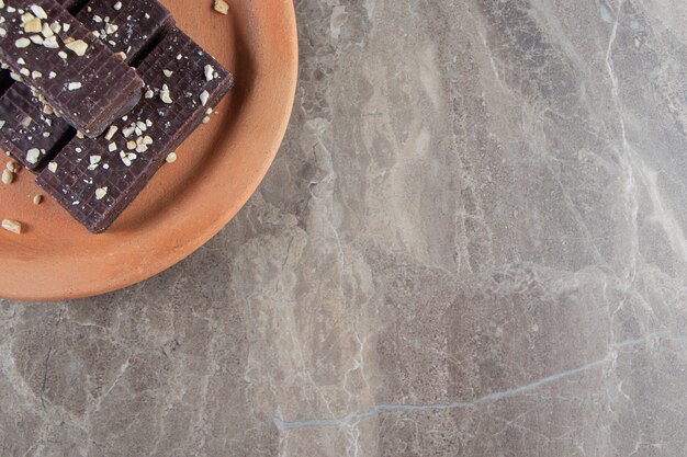 Gofre de chocolate sobre una placa de arcilla sobre mármol.