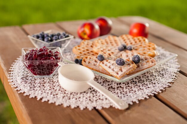 Gofre dulce con fruta en día de verano en mesa de madera