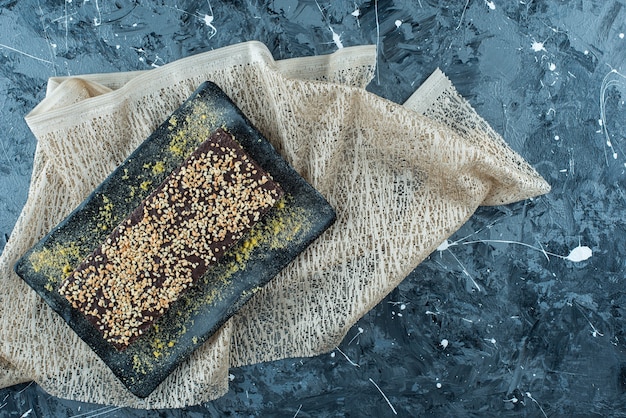 Gofre recubierto de chocolate en un plato sobre un mantel, sobre la mesa azul.