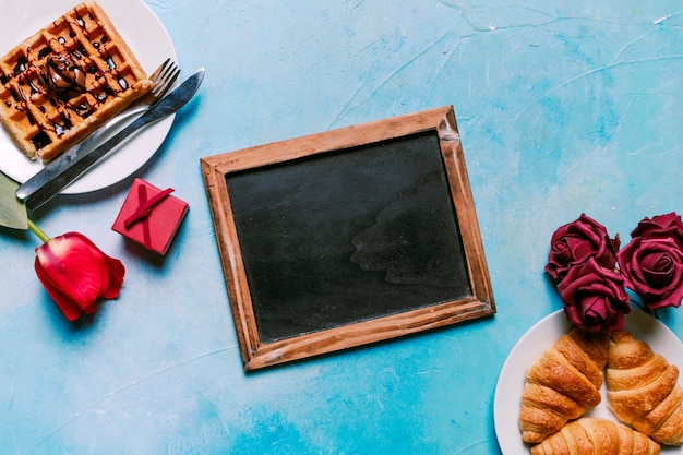 Foto gratuita gofres belgas con croissants y pizarra